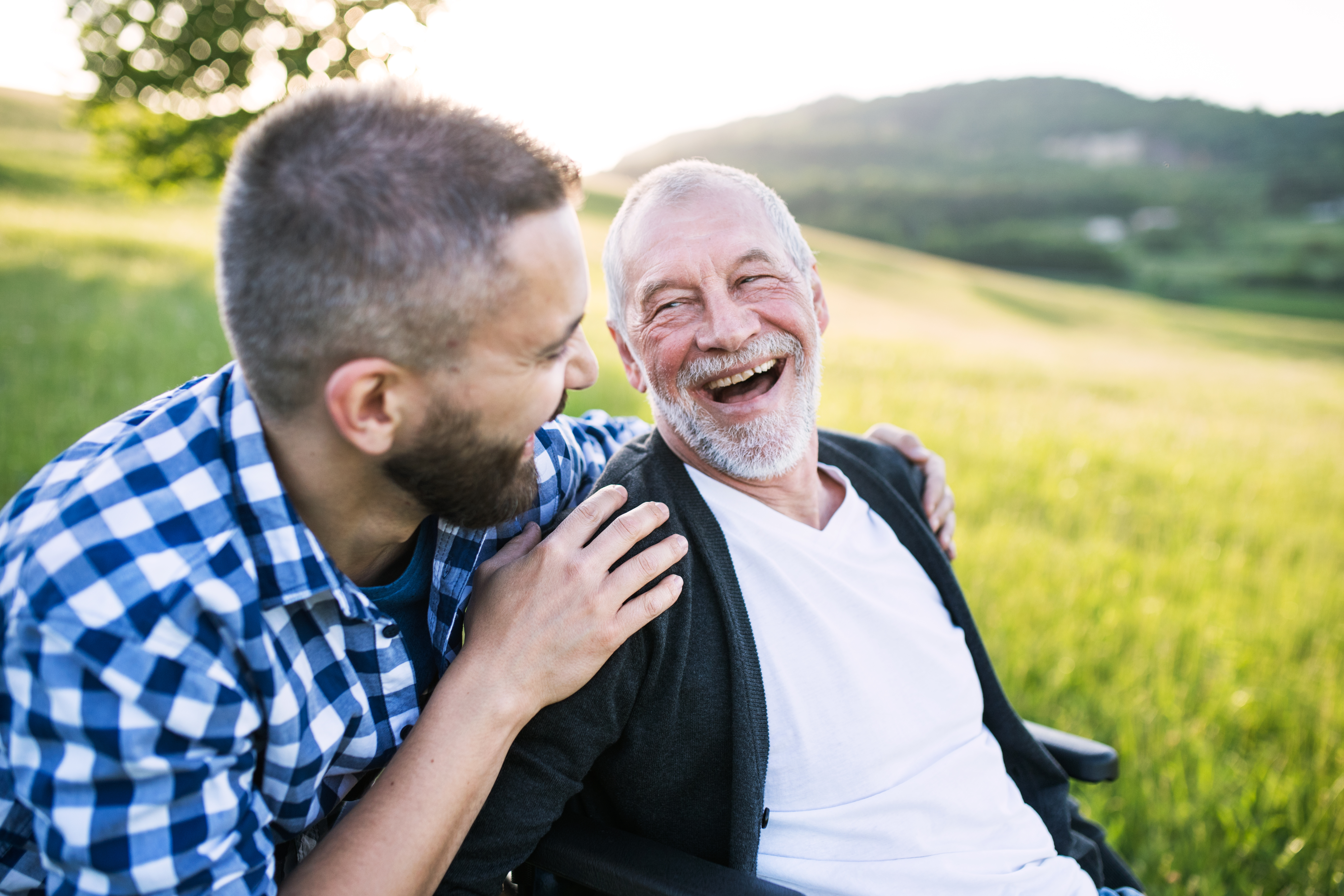 two men laughing together outside in the country