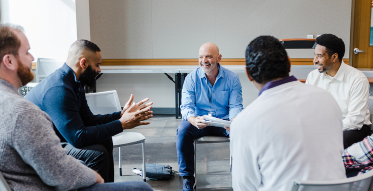 men sitting in a circle discussing