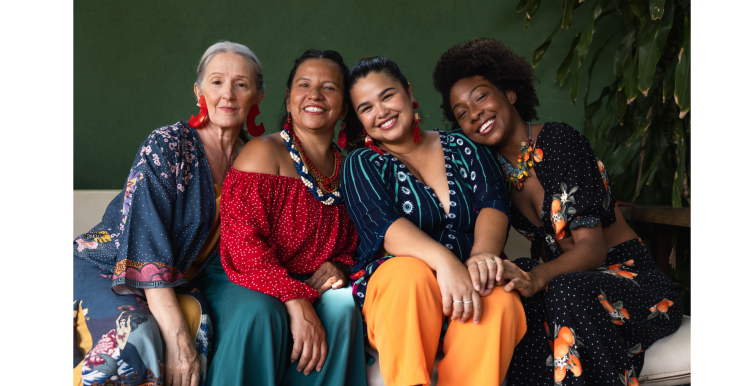 Four women sitting together smiling