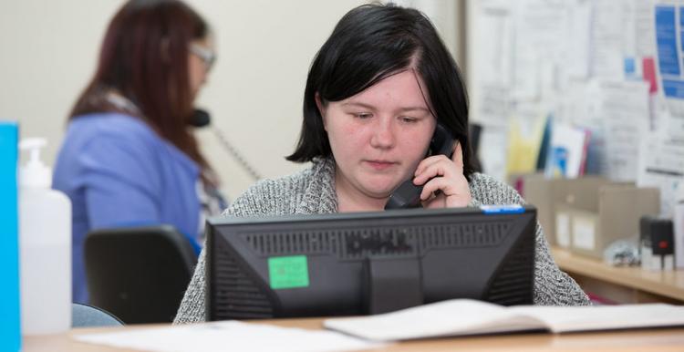 Receptionist on the phone at a GP surgery