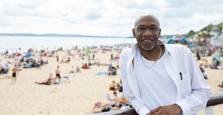 a man with a beach behind him