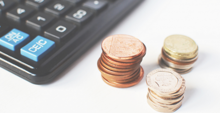 coins stacked up next to a calculator