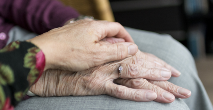 A hand resting on a pair of older hands