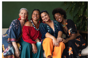 Four women sitting together smiling
